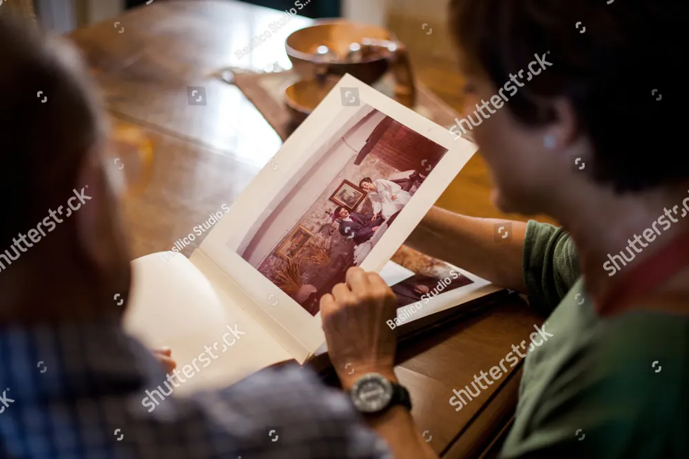 Two people looking through an old photo album together